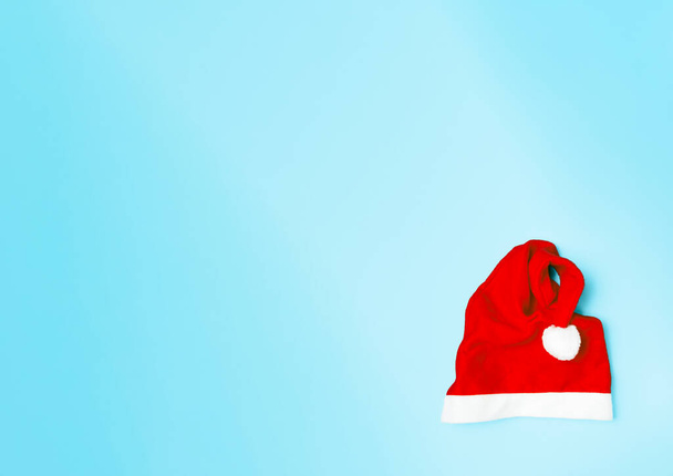 Chapeau Père Noël, rouge et blanc, pompon blanc, sur fond dégradé bleu, en bas du cadre, orientation horizontale - Photo, image