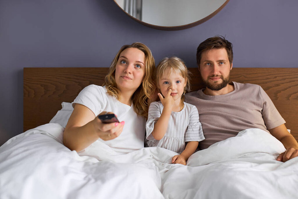 caucasian family watch tv on bed - Zdjęcie, obraz