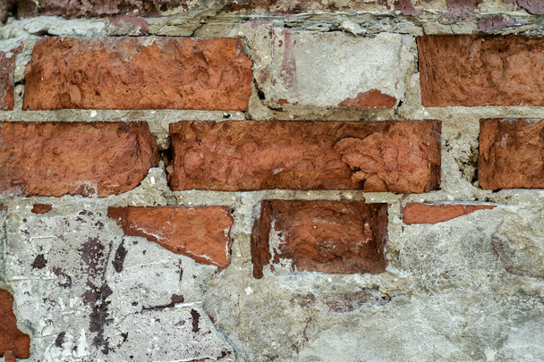 Texture of the old cracked brick wall of the building with remnants of cement - Fotó, kép
