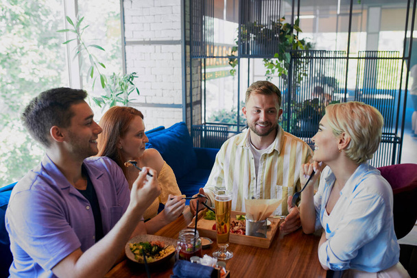 beautiful caucasian men and women hold friendly meeting in cafe - Фото, зображення