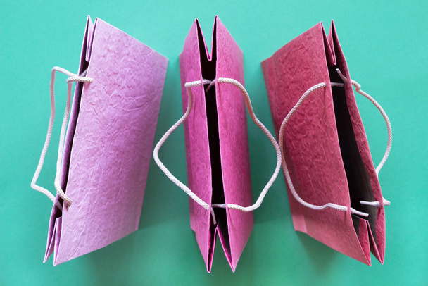 Sacos de compras de papel texturizados coloridos em fundo de hortelã. Conceito minimo de compras de moda online. vista superior, - Foto, Imagem