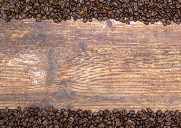 Granos de café derramados sobre un fondo de madera arriba y abajo - Foto, imagen