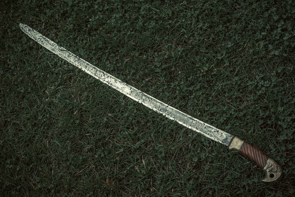 Cossack saber with a wooden handle on the green grass, cold weapon of the Russian army - Photo, Image