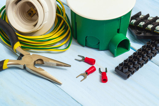 Werkzeug und Zubehör für Elektroinstallationen oder Reparaturen auf blauem Holztisch - Foto, Bild