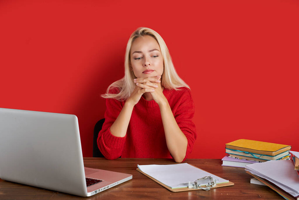 portrét sebevědomé bělošky blondýny sedící na kancelářském stole s laptopem a papíry - Fotografie, Obrázek
