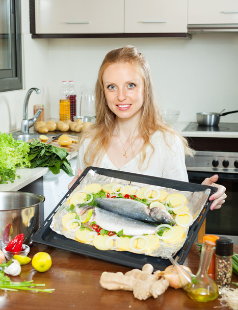 Ordinary housewife cooking fish and potatoes - Foto, imagen