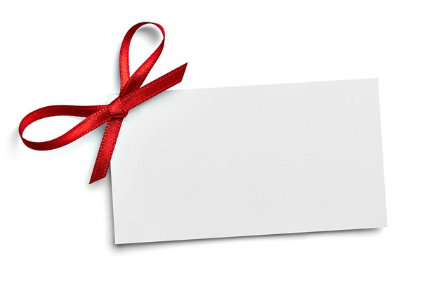 primer plano de una tarjeta de notas con lazo rojo sobre fondo blanco - Foto, Imagen