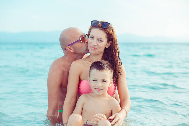 happy young family having fun while in vacations on the sea and beautiful beach, outdoors - Φωτογραφία, εικόνα
