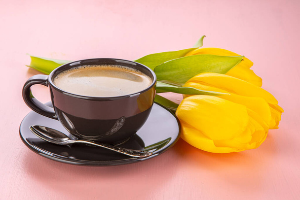 Spring still life on a pink background. Tulips and a cup of coffee - Foto, afbeelding
