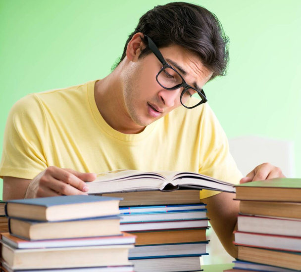 Студент, у которого слишком много книг, чтобы их прочитать перед экзаменом - Фото, изображение