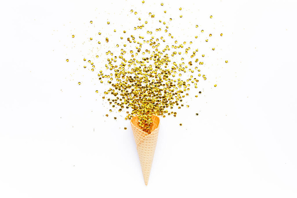 Yellow waffle cones with golden confetti tinsel isolated on white background. Flat lay, top view minimal festive. Holiday and celebration concept. - Fotoğraf, Görsel