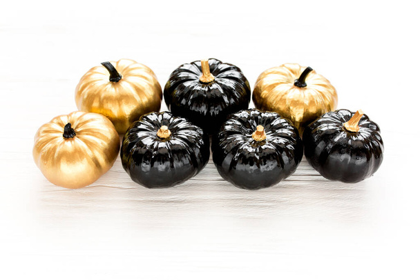 Stylish Halloween decorations. Decorative pumpkin black and gold Halloween isolated on white background. Flat lay, top view. - Fotografie, Obrázek