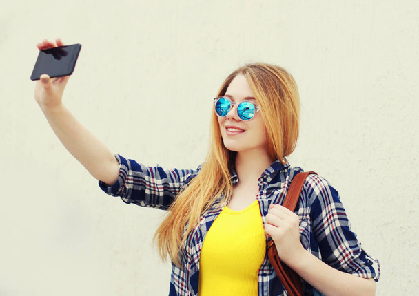 portrait of smiling teenager girl taking selfie picture by phone - Foto, afbeelding