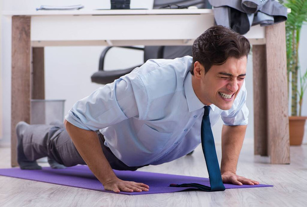Businessman doing sports in office during break - Photo, Image