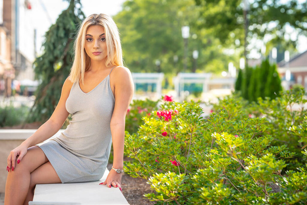 Un magnifique jeune modèle blond pose à l'extérieur tout en profitant d'une journée d'été - Photo, image