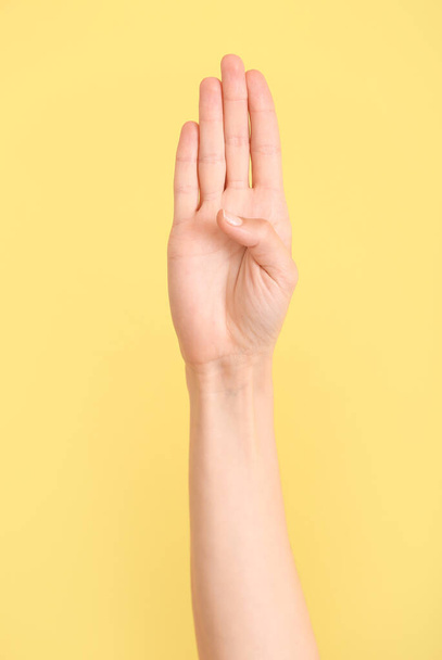 Рука показывает букву B на цветном фоне. Алфавит жестового языка - Фото, изображение