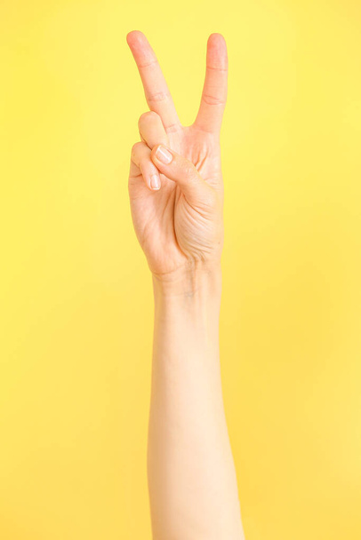 Mão mostrando a letra V no fundo da cor. Alfabeto de língua de sinais - Foto, Imagem