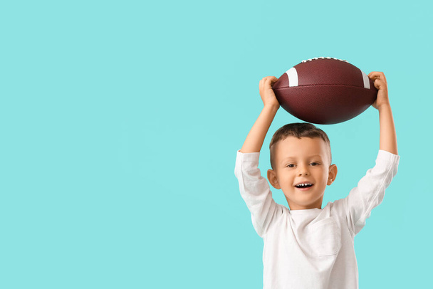 Kleine jongen met rugby bal op kleur achtergrond - Foto, afbeelding
