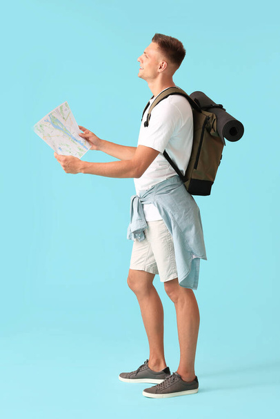 Male tourist with map on color background - Fotoğraf, Görsel