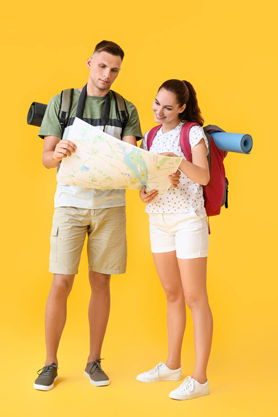 Pareja de turistas con mapa sobre fondo de color - Foto, Imagen