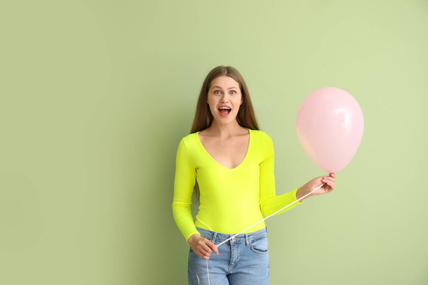 Young woman with balloon on color background - Foto, imagen