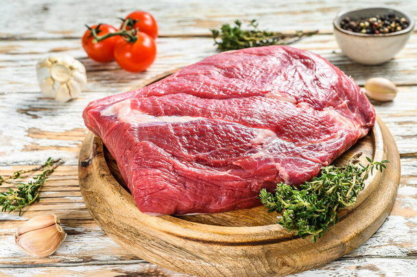 Roh geschnittenes Rindfleisch auf einem Holzbrett. Black Angus Beef. Weißer Hintergrund. Ansicht von oben. - Foto, Bild