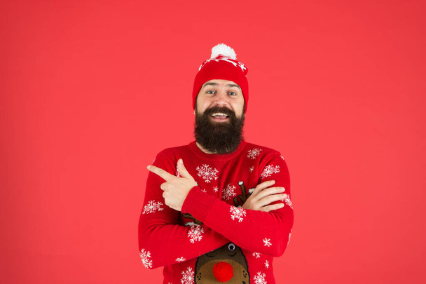 Christmas Sweater Party. Winter outfit. Good vibes. Fashion shop. Winter bucket list. Hipster bearded man wear winter sweater and hat red background. Happy new year concept. Join holiday party - Foto, imagen