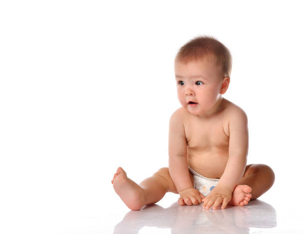 Little baby in nappy on floor stretching out by hand - Foto, imagen