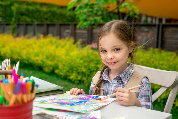 little girl drawing on her book and having fun outdoors. - Fotó, kép