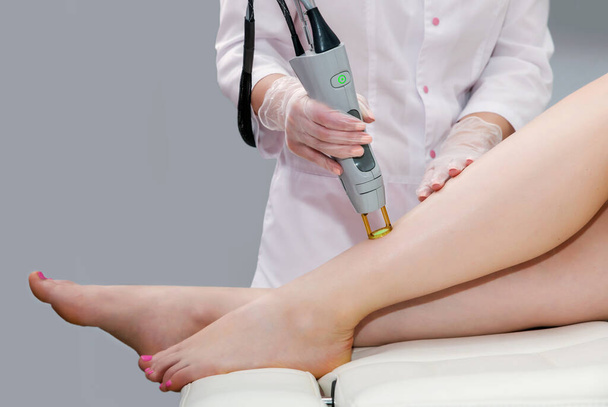 Hair removal cosmetology procedure from a therapist at cosmetic beauty spa clinic. Laser epilation and cosmetology. - Fotó, kép