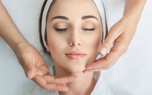 Face massage. Spa skin and body care. Close-up of young woman getting spa massage treatment at beauty spa salon. Facial beauty treatment. - Foto, Imagen
