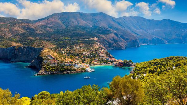 Assos village in Kefalonia, Greece. Turquoise colored bay in Mediterranean sea with beautiful colorful houses in Assos village in Kefalonia, Greece, Ionian island, Cephalonia, Assos village. - Photo, Image
