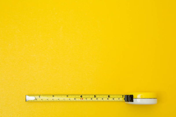 Yellow tape measure on yellow background and copy space - Фото, зображення