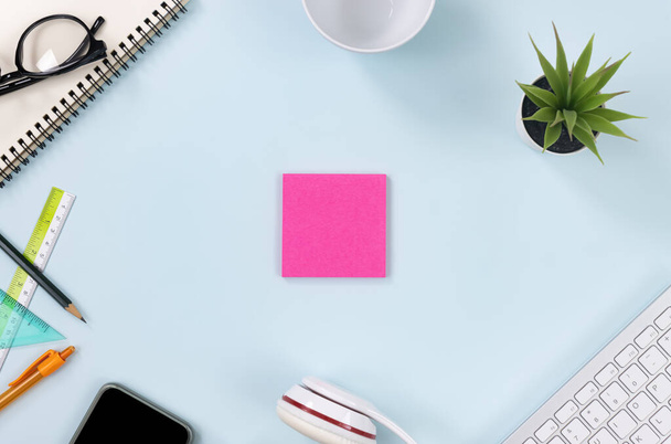 Pink Sticky Note or Note Pad and Office Supplies as Keyboard, Pen, Lápis, Plantas de Escritório, Notebook, Óculos, Smartphone, Headphone, Coffee Cup on Modern Clean Creative Office Desk or Table on Top View - Foto, Imagem