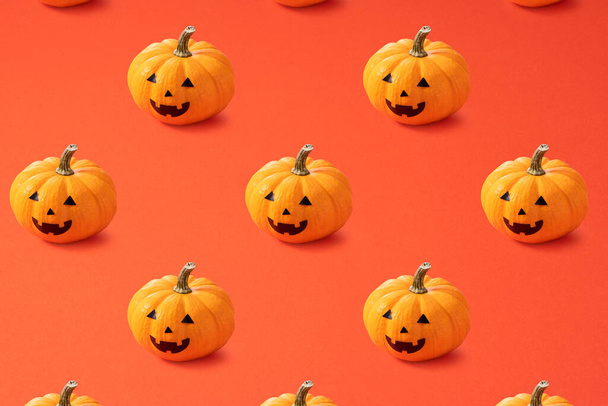 Jack-o-lanterns lined up regularly on an orange background - Фото, зображення