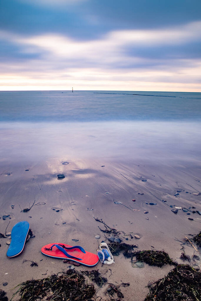 Flips flop és úszás szemüveg a tenger mellett a homokban, közel a vízhez. Koncepció - tengerparti nyaralás, tengerparti nyaralás  - Fotó, kép