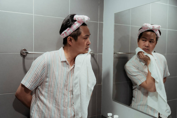 Asiático gay lavándose la cara para refrescarse. Es una especie de cuidado corporal de alguien que tiene amor propio.. - Foto, imagen
