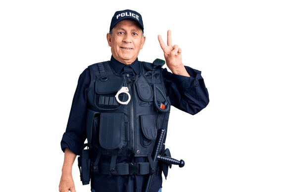 Senior handsome man wearing police uniform smiling with happy face winking at the camera doing victory sign. number two.  - 写真・画像