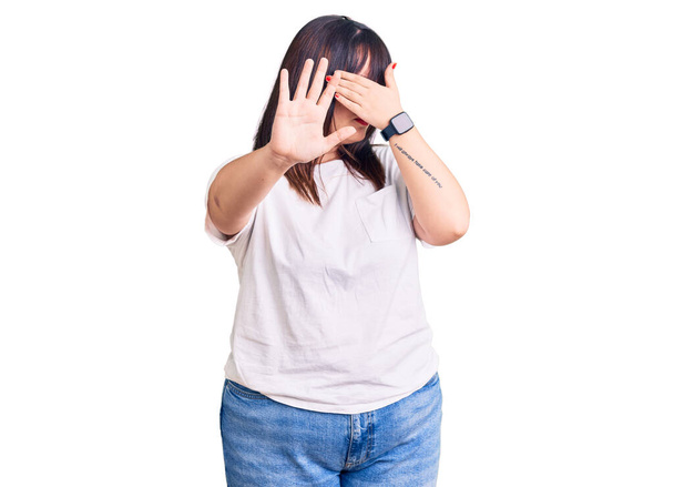 Young plus size woman wearing casual clothes covering eyes with hands and doing stop gesture with sad and fear expression. embarrassed and negative concept.  - Fotó, kép