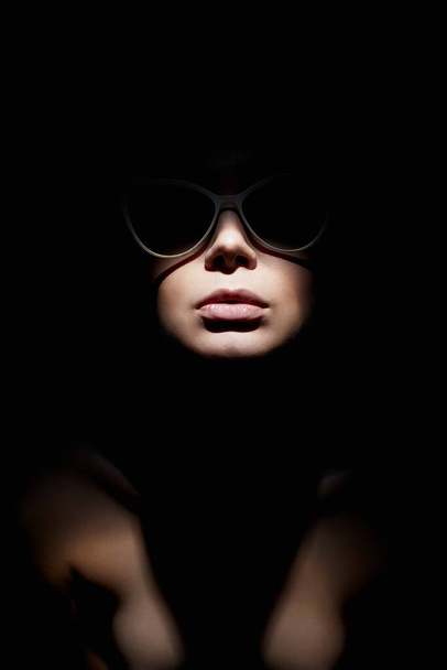 retrato de mujer hermosa en gafas. Modelo chica estancia en la oscuridad - Foto, Imagen