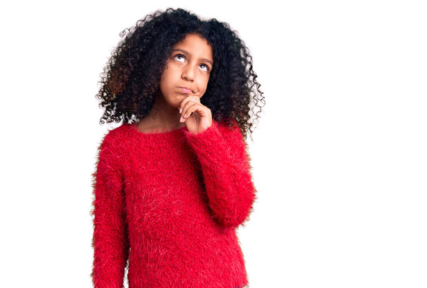 Африканська американська дитина з кучерявим волоссям у повсякденному зимовому светрі серйозно особа думає про питання з рукою на підборіддя, роздумуючи про плутанину ідеї  - Фото, зображення