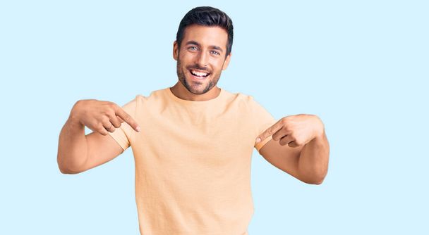 Young hispanic man wearing casual clothes looking confident with smile on face, pointing oneself with fingers proud and happy.  - Photo, Image