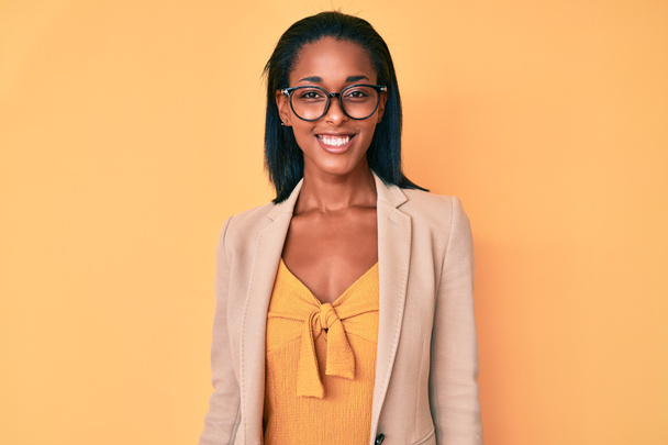 Mujer afroamericana joven vestida con ropa de negocios con una sonrisa alegre y fresca en la cara. persona afortunada.  - Foto, Imagen