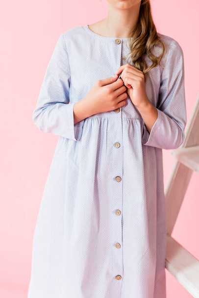 Girl in a blue linen dress posing on a blue background. The principle of simplicity and environmental friendliness of clothing. Vertical photo - Foto, Imagem