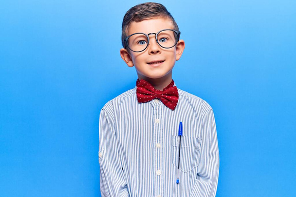 Niño rubio lindo con corbata de lazo nerd y gafas con una sonrisa feliz y fresca en la cara. persona afortunada.  - Foto, Imagen