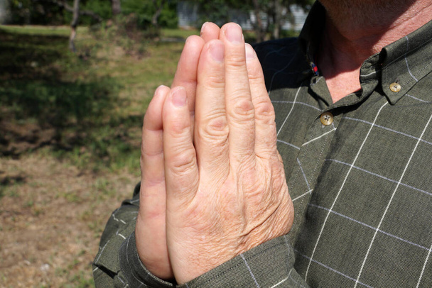 mužské ruce složené v modlitbě v přírodě. - Fotografie, Obrázek