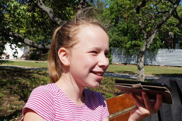 дівчина розмовляє в парку по телефону і сміється
. - Фото, зображення