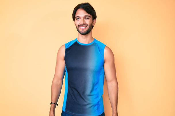Handsome hispanic man wearing sportswear looking positive and happy standing and smiling with a confident smile showing teeth  - Foto, Bild