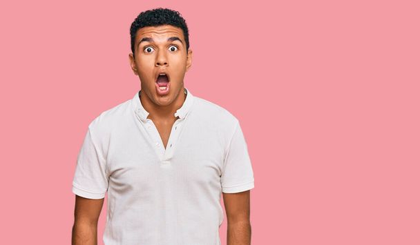 Young arab man wearing casual clothes afraid and shocked with surprise and amazed expression, fear and excited face.  - Photo, image