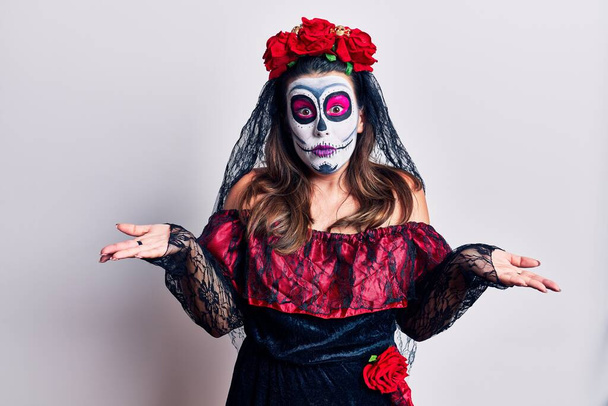 Young woman wearing day of the dead costume over white clueless and confused with open arms, no idea concept.  - Zdjęcie, obraz